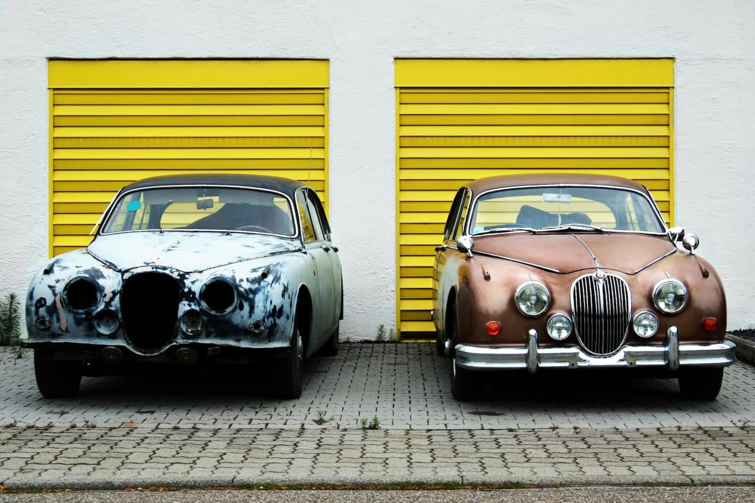 Two cars parked side by side. One is new and the other is old.